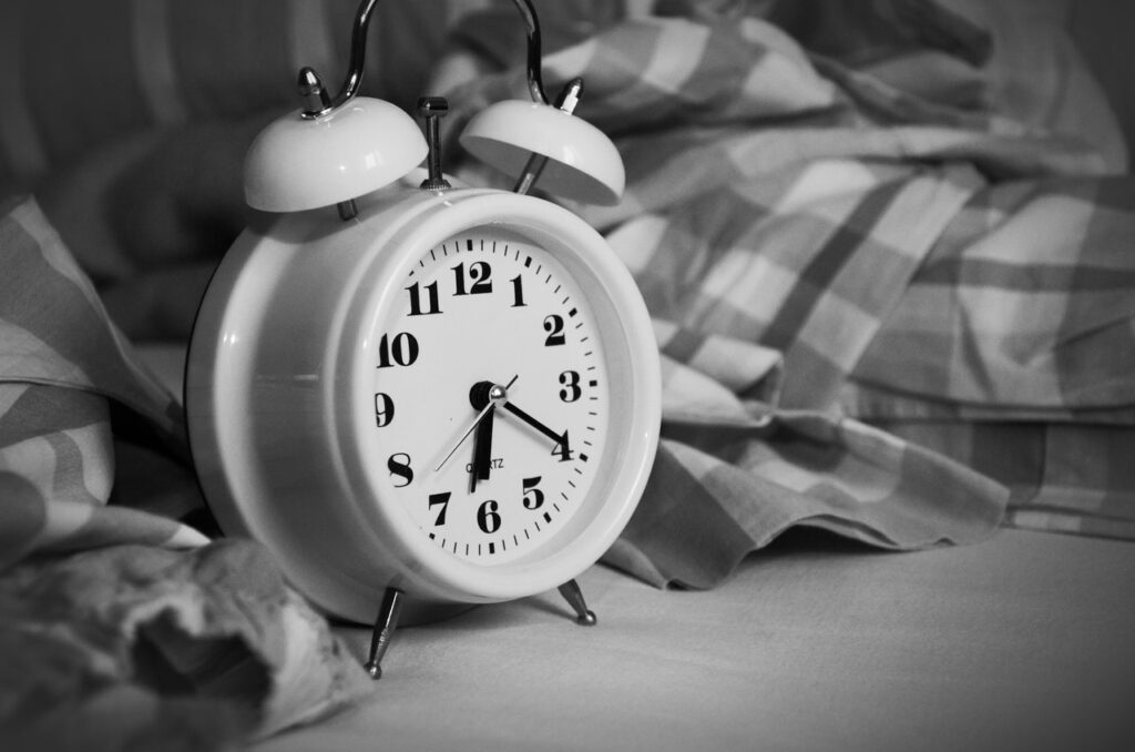An alarm clock in black and white, highlighting the clear connection between smoking and sleep apnea.